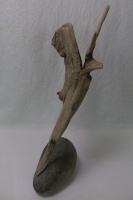 Driftwood precariously perched on the edge of a pebble