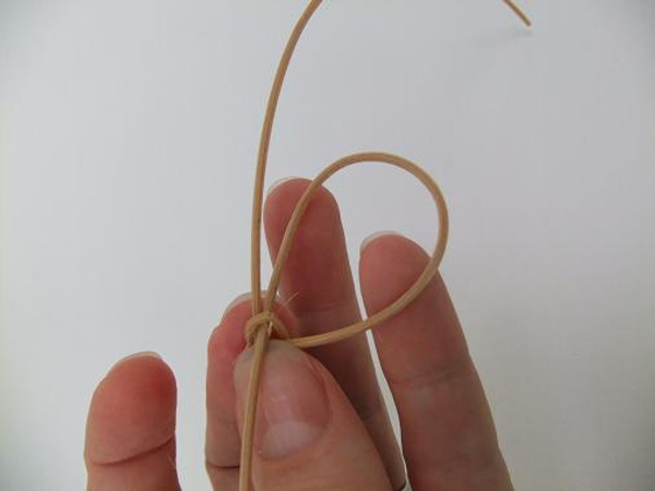 Thread one dangling leg of the rattan knot back through