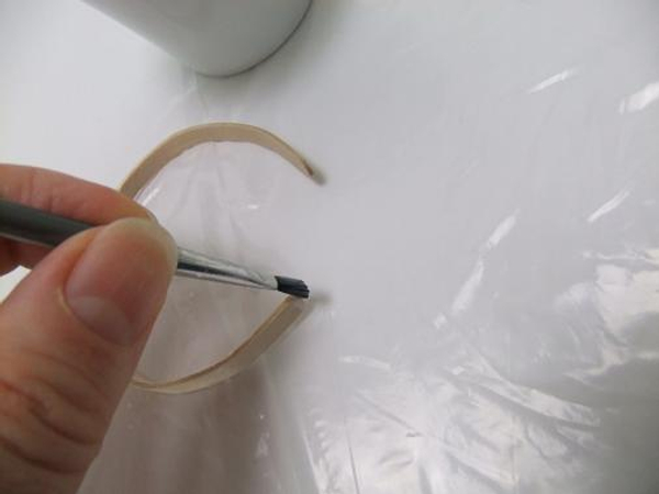 Paint a small drop of glue on the end of the curved stir stick.