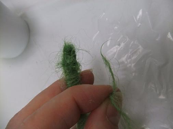 Place a drop of glue on the knot and cut the dangling wool bit short