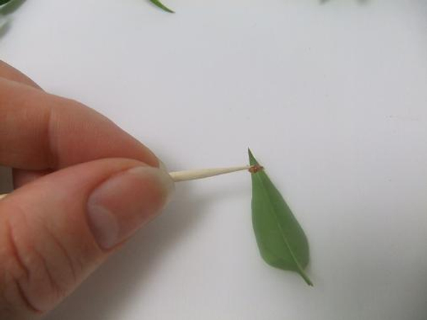 Place a tiny drop of glue on the tip of the leaf