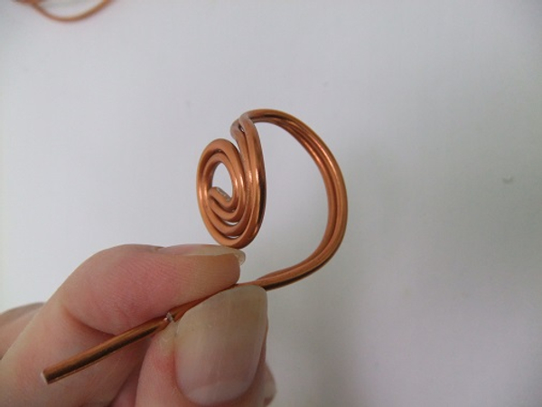 Curve the wire down and around to create the ring part that wraps around the wearers finger