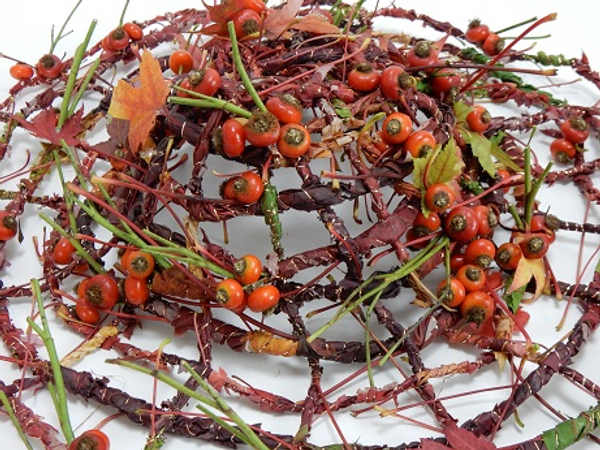 Weaving a hat with an autumn leaf and rose hip garland