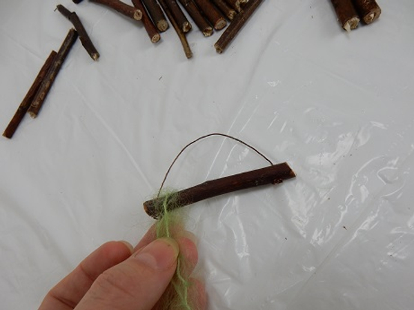Pull the wool over the twig so that the twig lies in the middle point of the wool strand