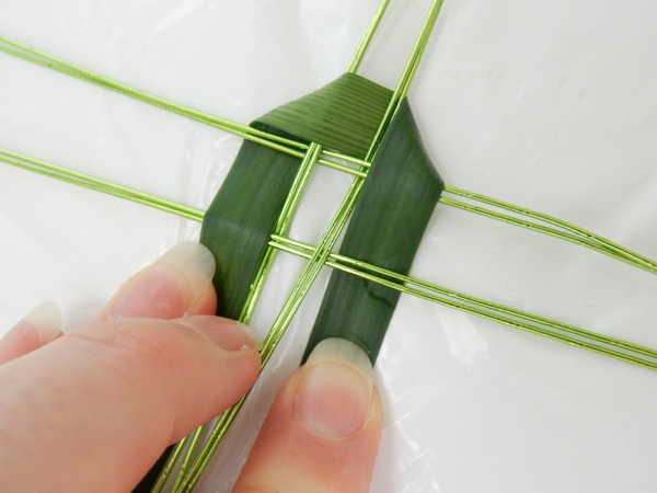 Weave the garland over the first two and under the next two strands