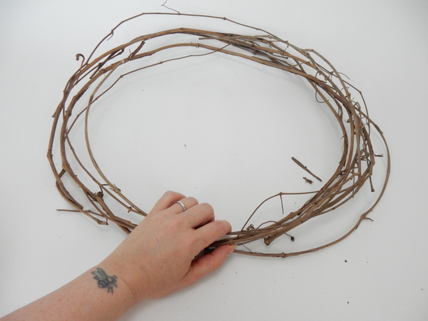 Place a dried vine wreath on a flat working surface