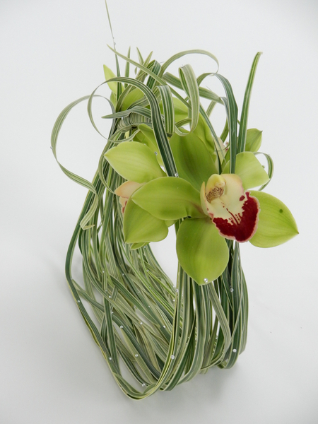 Cymbidium orchids and curled grass with crystals on a basket