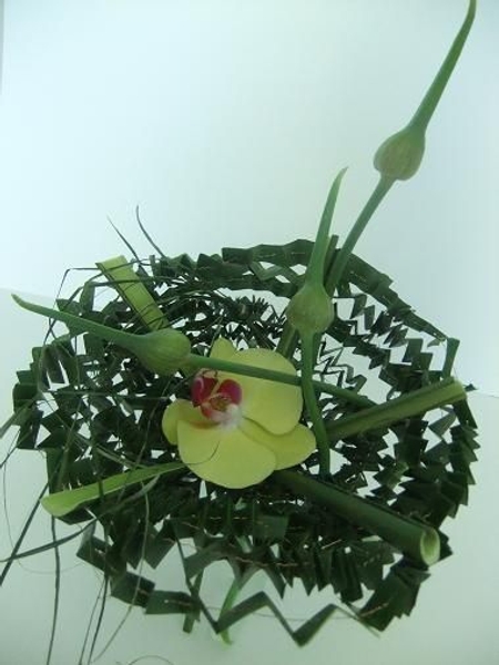 Allium flower heads and orchids in a pleated basket