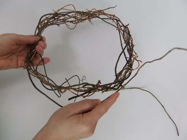 Continue weaving in willow twigs and wire to complete the wreath Continue weaving in willow twigs and wire to complete the wreath