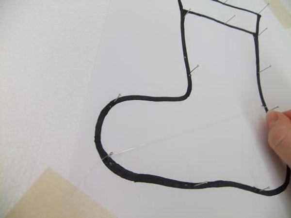 Tie the fishing line between the pins and secure with knots Tie the fishing line between the pins and secure with knots