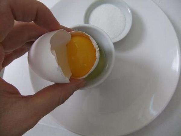 Pour the yolk from the one side of the shell to the other Pour the yolk from the one side of the shell to the other