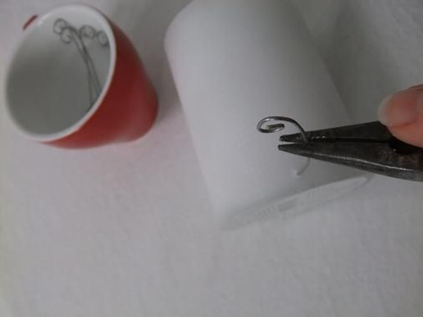 Press the wire into the candle wax with pliers Press the wire into the candle wax with pliers
