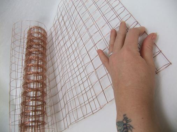 Fold a section of biodegradable copper mesh in half.