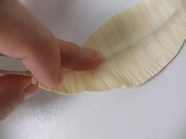 Carefully bend and curve the wooden feather. Carefully bend and curve the wooden feather.