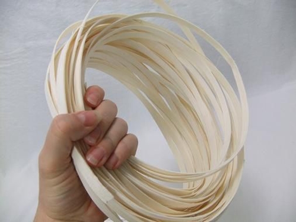 Gather a few strands of white Midelino flat coils in your hand Gather a few strands of white Midelino flat coils in your hand