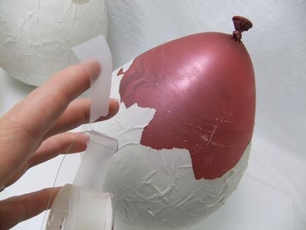 Stick a short section of clear tape to the balloon. Stick a short section of clear tape to the balloon.