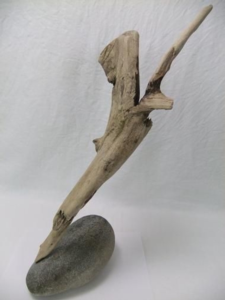 Glue the other side of the wire into the driftwood at an angle to make the wood appear to be precariously perched on the pebble. Glue the other side of the wire into the driftwood at an angle to make the wood appear to be precariously perched on the pebble.