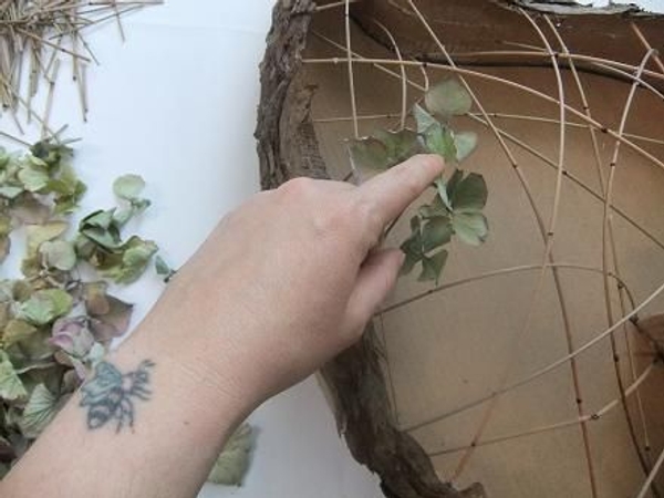 Continue to build up the design with dried flowers. Continue to build up the design with dried flowers.