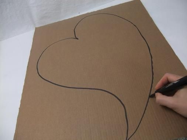 Draw a large heart shape on the cardboard. Draw a large heart shape on the cardboard.