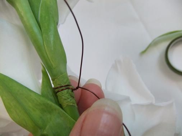 Wrap the wire twice around the stem and twist. Wrap the wire twice around the stem and twist.