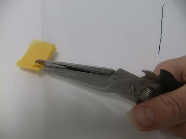Fold the strip of tissue paper and cut into it Fold the strip of tissue paper and cut into it