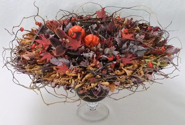 Rose hips, pumpkin tree plant, and a cymbidium orchid and willow nestled in a rosette of autumn leaves Rose hips, pumpkin tree plant, and a cymbidium orchid and willow nestled in a rosette of autumn leaves