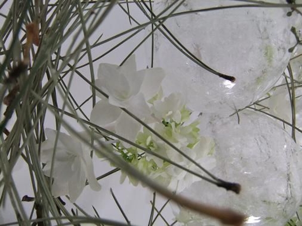 Frosted glass baubles rest in a bed of White Shooting Star Hydrangeas.