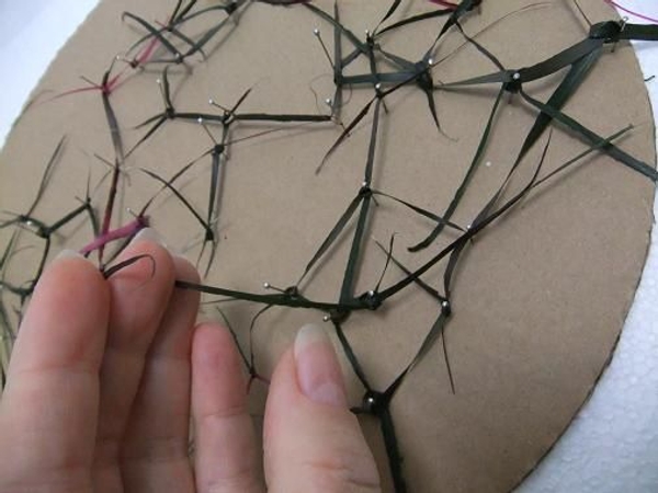 Press the strands down to lie flat on the cardboard Press the strands down to lie flat on the cardboard