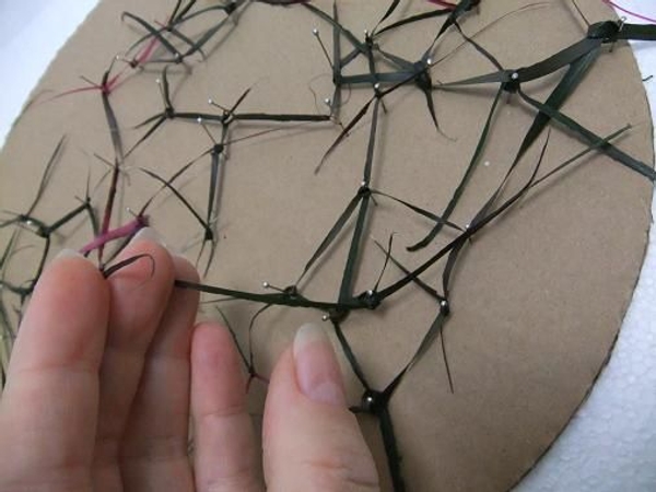 Press the strands down to lie flat on the cardboard