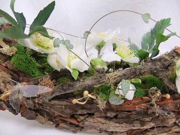 Again Reindeer moss, Hellebore flowers, Lichen covered twigs, Rosary vine and dried mushrooms decorate the design Again Reindeer moss, Hellebore flowers, Lichen covered twigs, Rosary vine and dried mushrooms decorate the design