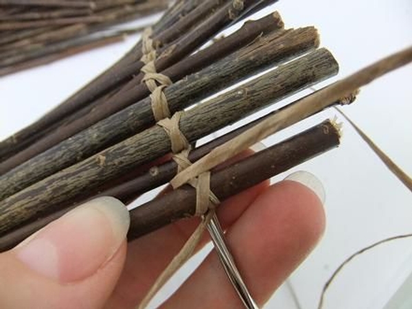 Fold the first wire between the twigs and around the circle Fold the first wire between the twigs and around the circle