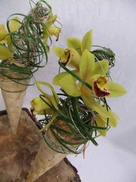 Secure the orchids by weaving in strands of ripped foliage Secure the orchids by weaving in strands of ripped foliage