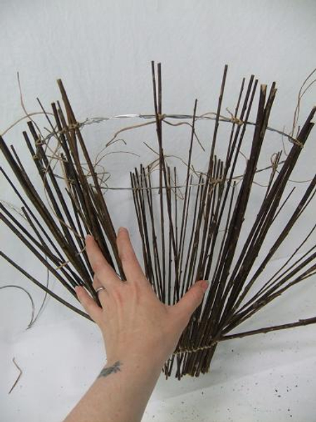 Fill in the gaps by spacing out the remaining twigs and binding it to the circle.