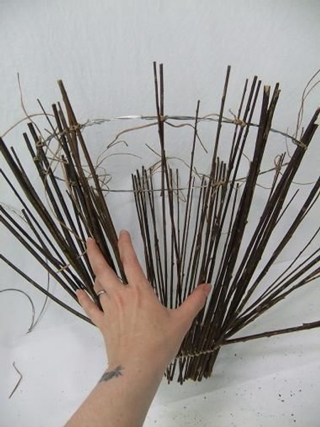 Fill in the gaps by spacing out the remaining twigs and binding it to the circle. Fill in the gaps by spacing out the remaining twigs and binding it to the circle.