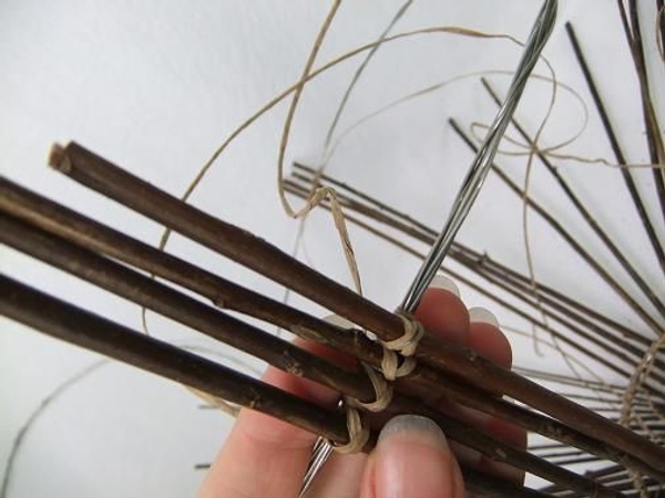To make it easier to space out the twigs start by tying four twigs on opposite ends of the circle To make it easier to space out the twigs start by tying four twigs on opposite ends of the circle