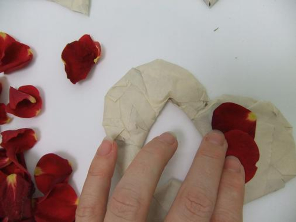 Gently press the rose petals to stick to the tape