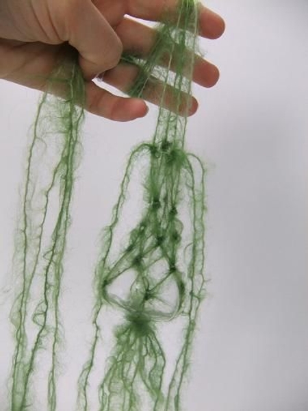 Divide the wool again and let four strands dangle down the vase Divide the wool again and let four strands dangle down the vase
