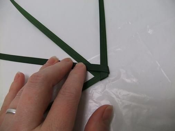 Fold the blade of grass on the right up at an angle and over the second blade of grass Fold the blade of grass on the right up at an angle and over the second blade of grass