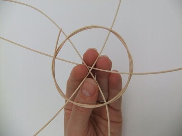 Add a third piece of rattan and weave it through the previous pieces Add a third piece of rattan and weave it through the previous pieces