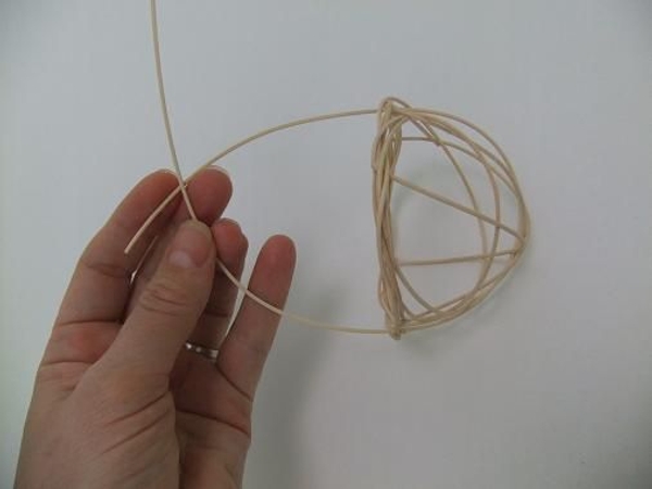 Fold the two dangling rattan pieces over the top of the basket Fold the two dangling rattan pieces over the top of the basket