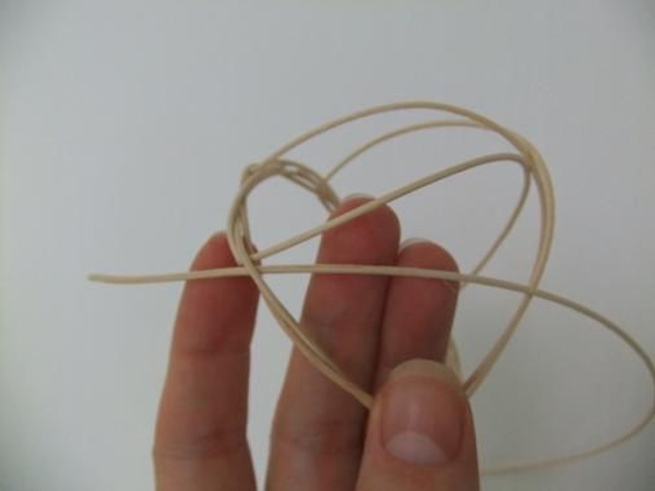 Hook a long piece of rattan through the wreath and weave it through the basket Hook a long piece of rattan through the wreath and weave it through the basket