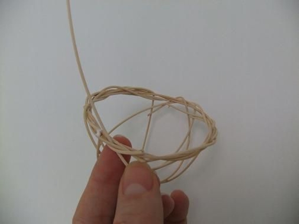 Weave in another long rattan piece to create the basket handle Weave in another long rattan piece to create the basket handle
