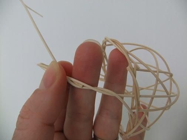 Weave in another section of rattan and weave it around the handle from the one side to the other Weave in another section of rattan and weave it around the handle from the one side to the other