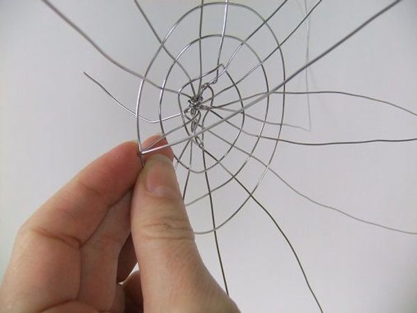 Bend the first wire up and over the spiral wire Bend the first wire up and over the spiral wire