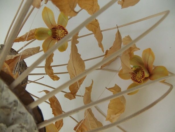 Display Cymbidium orchids and autumn leaves in a handmade basket