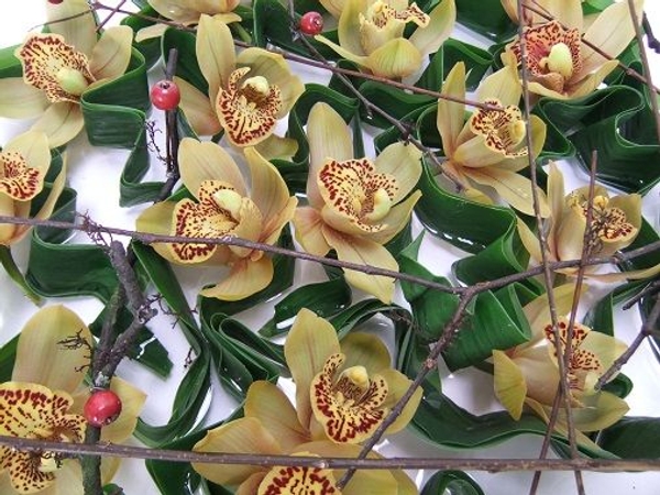 Fold a few leaves in a zig zag pattern to support the orchids Fold a few leaves in a zig zag pattern to support the orchids