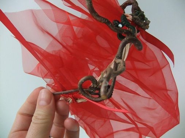 Glue the twigs and tiny flowers to the wreath to decorate Glue the twigs and tiny flowers to the wreath to decorate