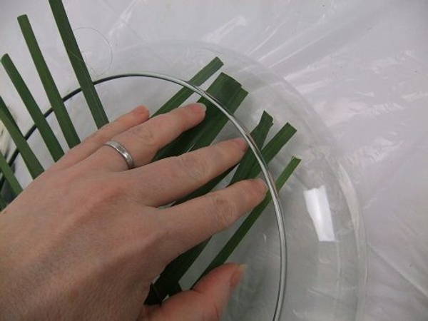 Gently tuck the first side of foliage strands into the container Gently tuck the first side of foliage strands into the container