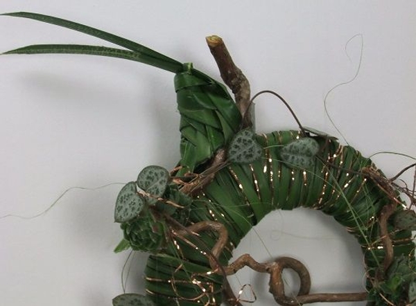 Weaving a grasshopper from foliage.