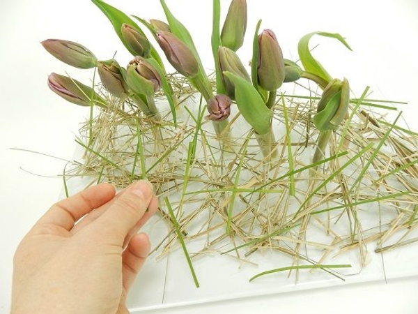 Add the fresh flowers and snippets of green grass. Add the fresh flowers and snippets of green grass.